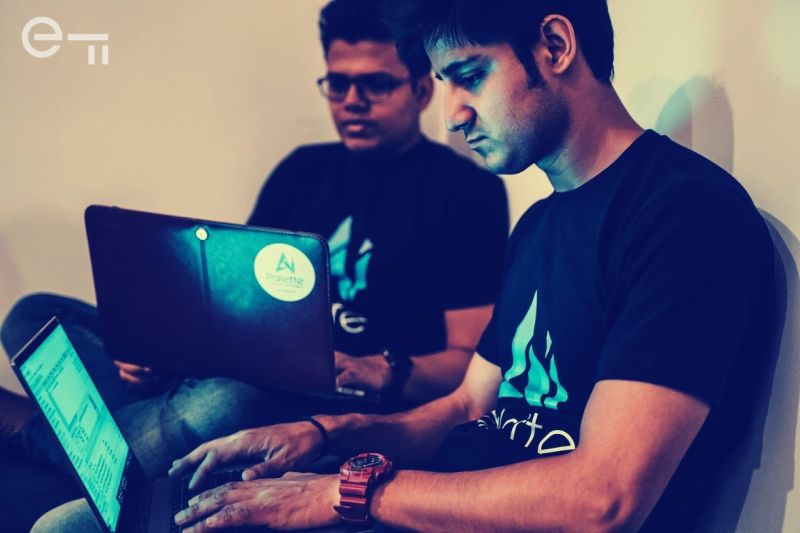 Two men working on laptops